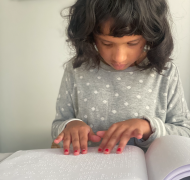 Ankitha reading a book in braille 
