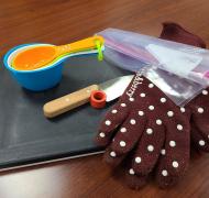 Gloves, cutting board, measuring cups, and a knife