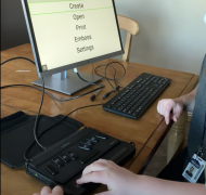 Child using braille notetaker with refreshable braille display