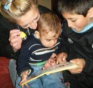 Mother reading with two sons
