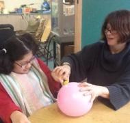 Student with teacher and pink balloon