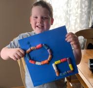A boy holds up his Magic Nuudle design.