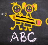 Cartoon type image with a boy and girl holding a large pencil on a chalkboard with ABC and a heart around it