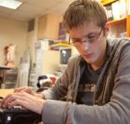 A teenage boy uses a braille notetaker.