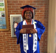 Jasmyn with her cap and gown and diploma at FSDB graduation