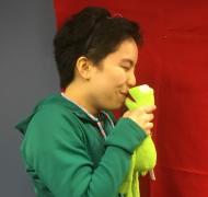 Teen age girl holding Kermit the frog near her mouth