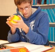 A student holds a 3-D math manipulative