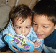 A boy reads with his younger brother.