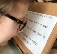A boy reading text on a slant board