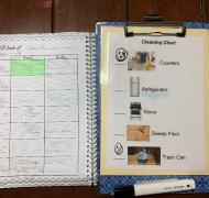 Student clipboard with photo images, beside a written lesson plan