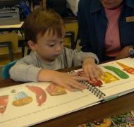 A young boy explores tactile illustrations.