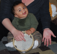Young child plays the tambourine