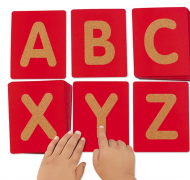 ABC flashcard letters with child hands exploring 