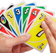 Hand holding a uno cards that have print and braille 