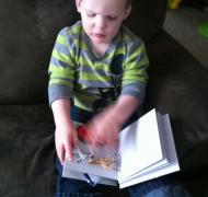 A young boy examines a tactile book.