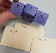 Picture of word cube with braille labels and braille word cards