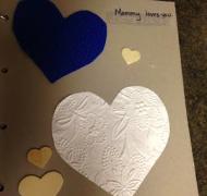 Book with hearts and says "Mommy Loves You"