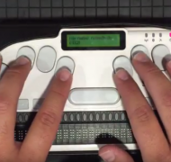 Fingers on keyboard of Braille Sense