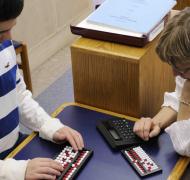 Student and teacher using abacus