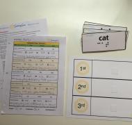 Flashcards with Braille and Printed Lesson Sheets on Desk