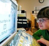 Girl with glasses looks at a computer screen