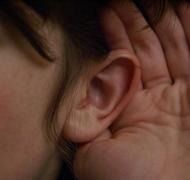 Ear with hand cupped around it