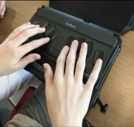 Student writing with a braille notetaker