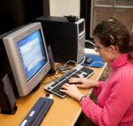 Teenage girl with fingers on computer keyboard