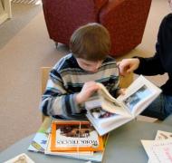 A young boy examines a book