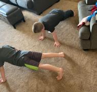 Two boys doing push-ups in the living room