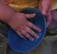 A child's hands explore a bowl.