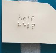 Index card with "help" in print and braille
