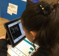 A girl using an iPad to do a math problem