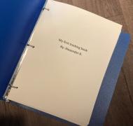Blue binder open with a page that says: my first tracking book