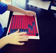 A boy uses the EZee Abacus from APH