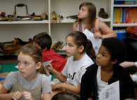 A group of students look toward the front of the classroom.