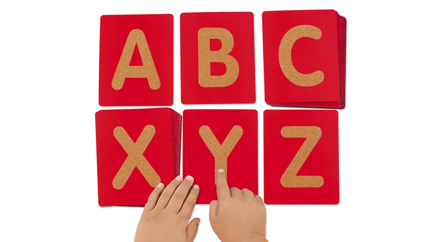 ABC flashcard letters with child hands exploring 