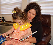 Woman and girl look at book together.