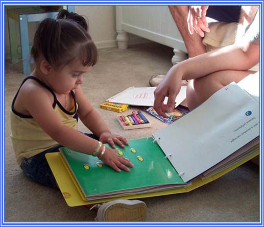 Photo of young girl examining tactile book