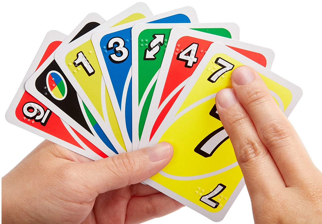 Hand holding a uno cards that have print and braille 