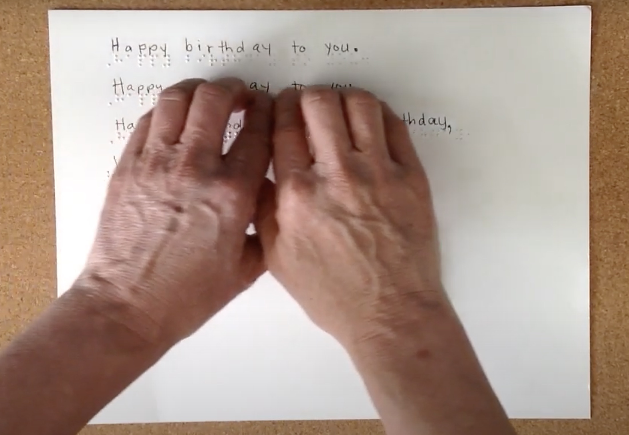 Two hands reading braille text