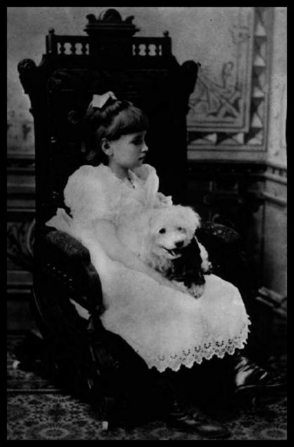 Helen Keller as a young girl with her dog on her lap