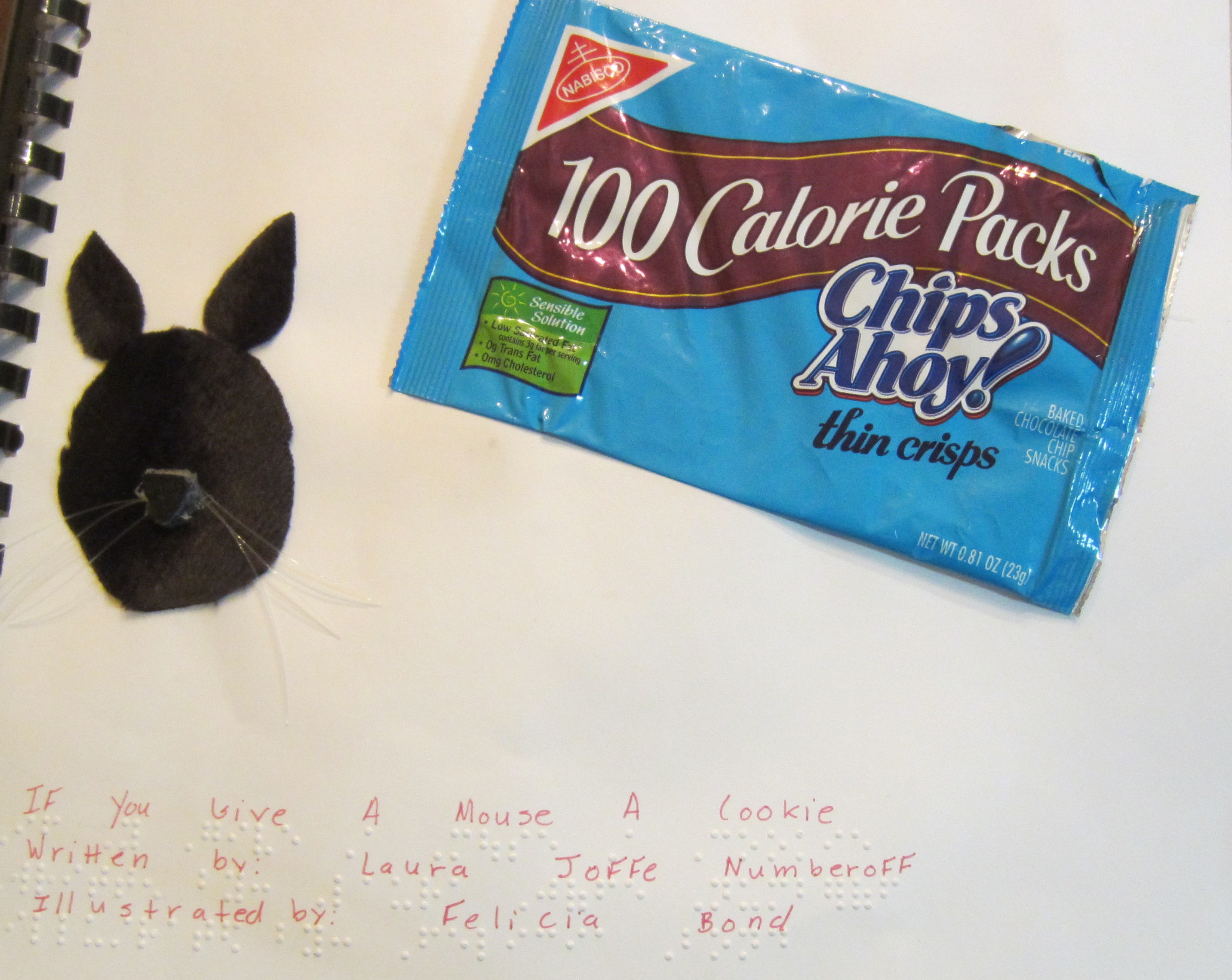 a felt mouse and an empty cookie package on the cover of a book