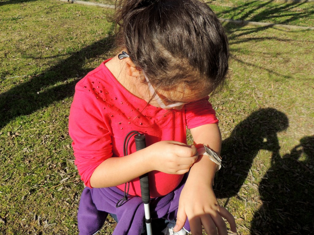 A girl examines a bracelet on her wrist