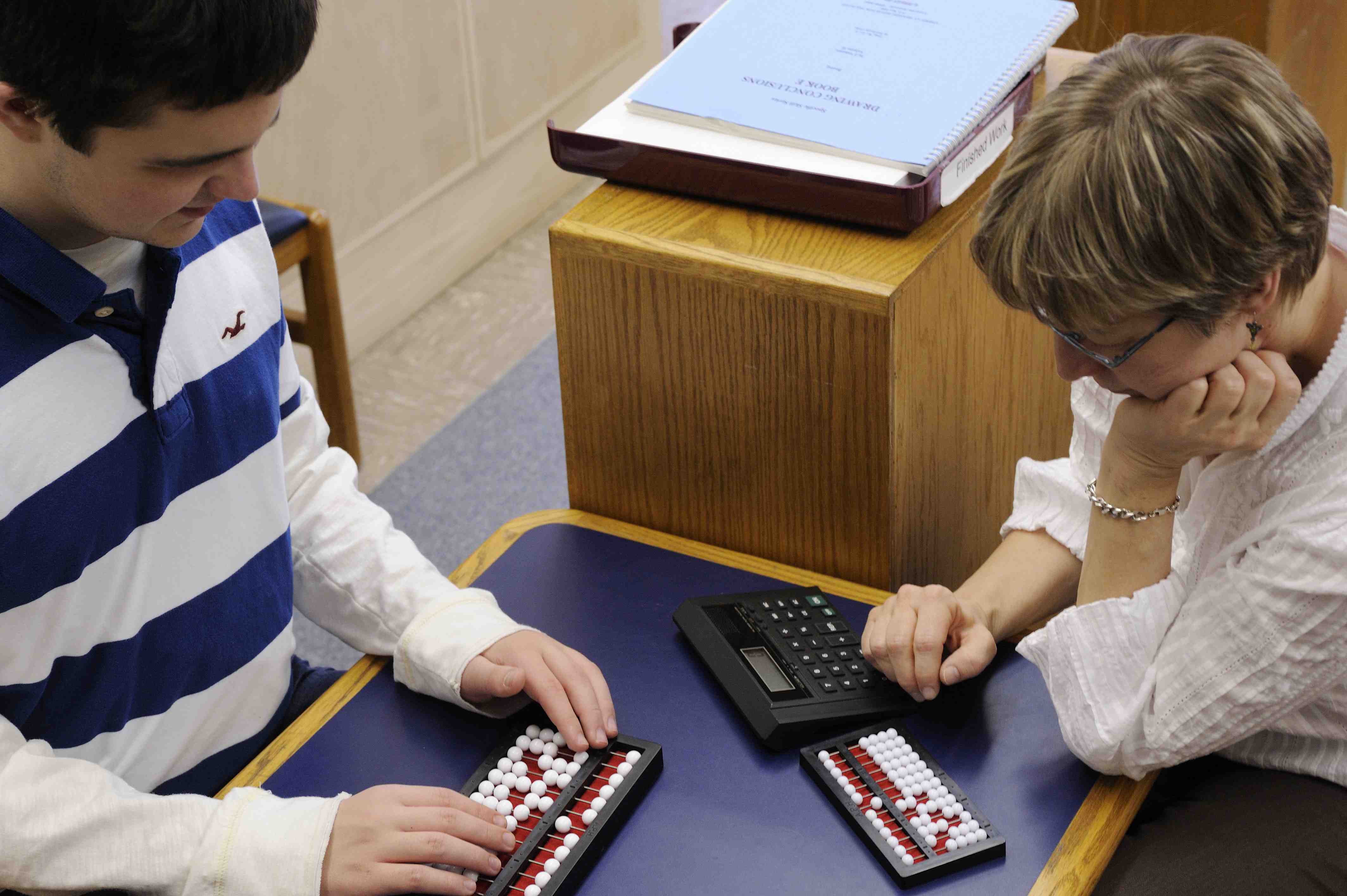 Student and teacher using abacus