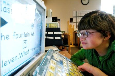 Girl with glasses looks at a computer screen
