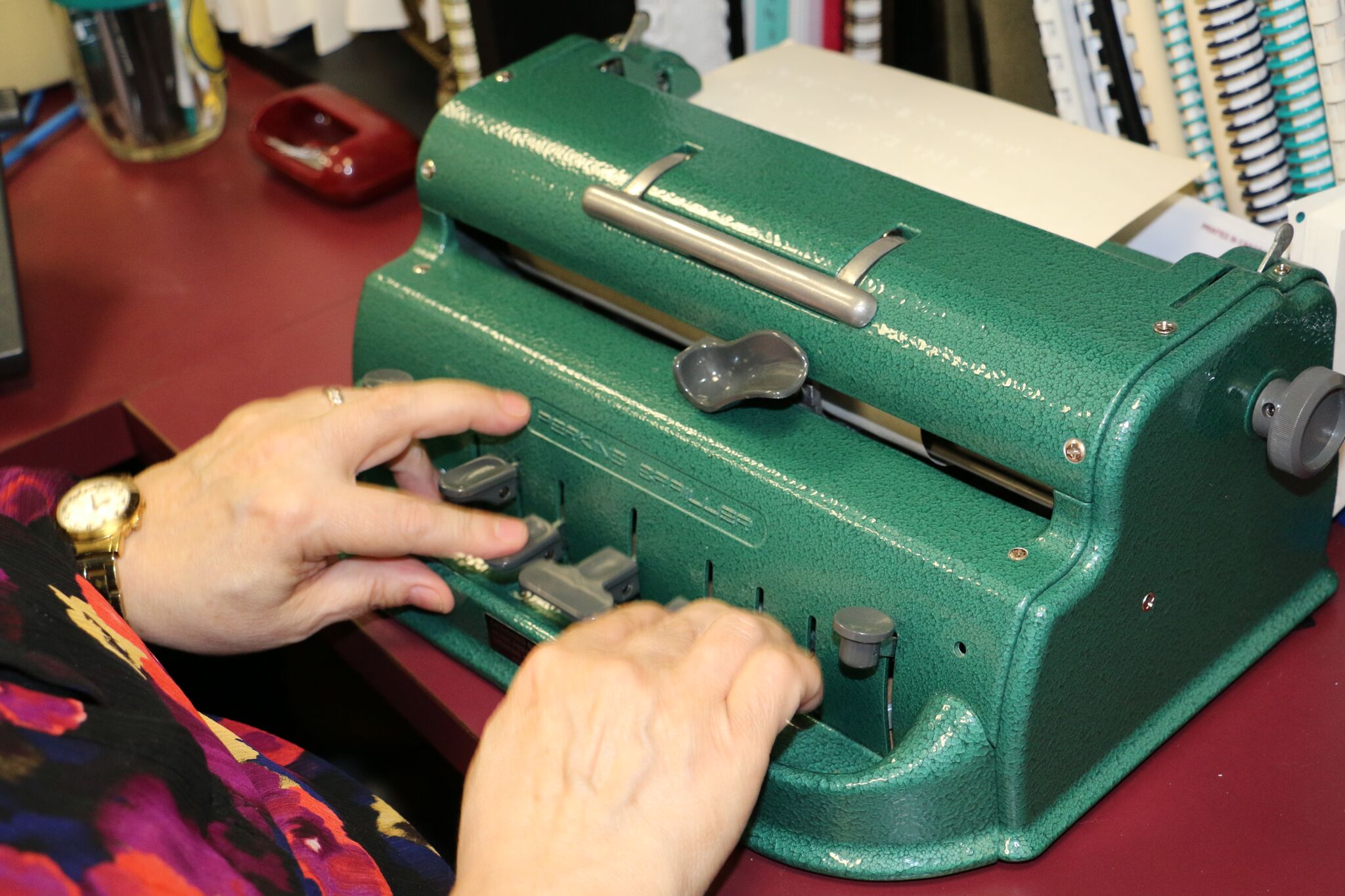 An adult using a braillewriter