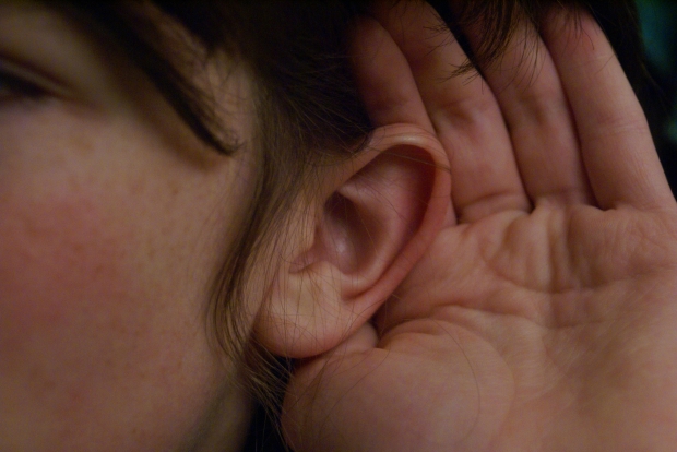 Ear with hand cupped around it