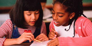 Two girls examine a text together