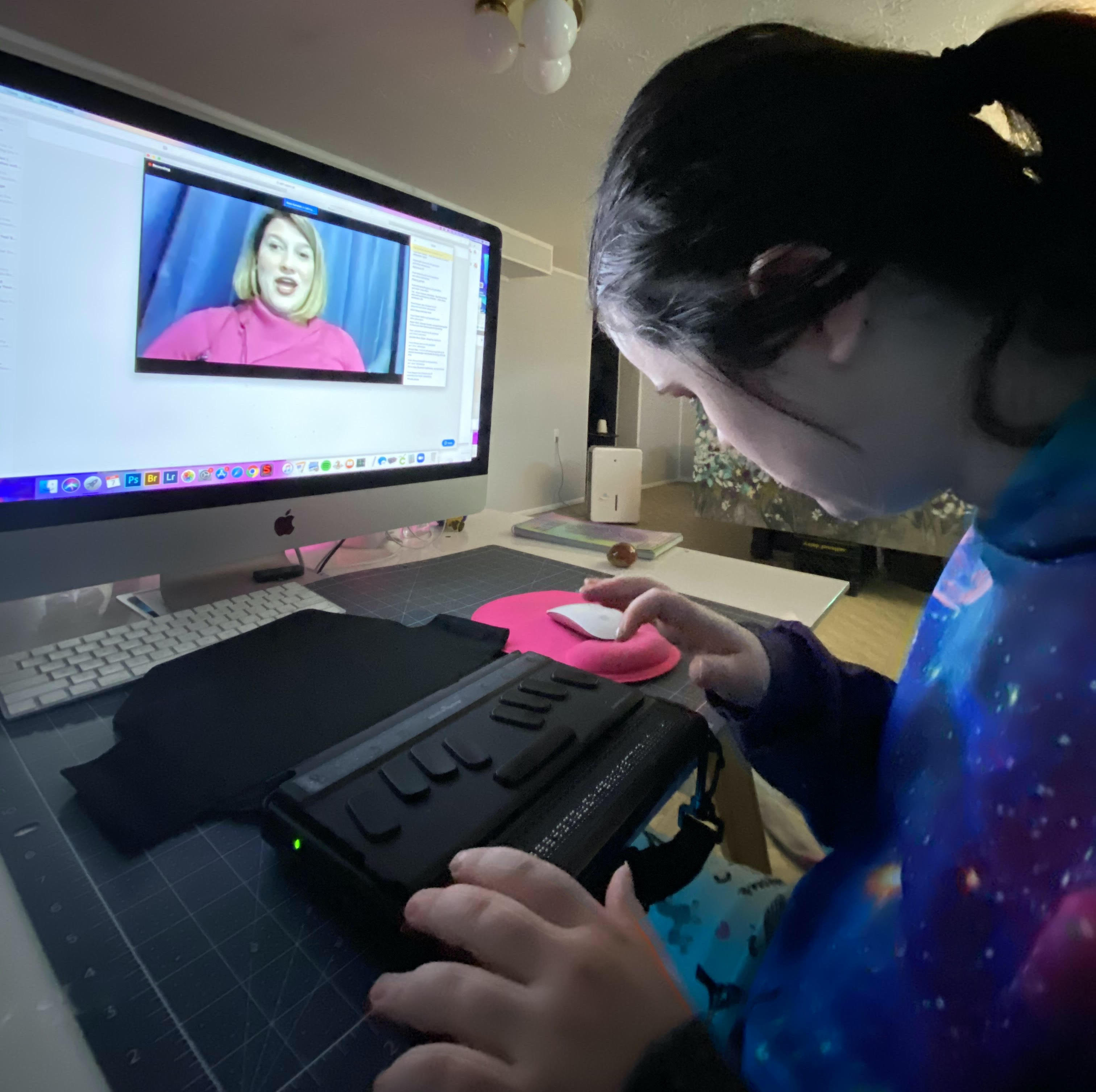 A girl listens to a broadcast which she has accessed with her braille note